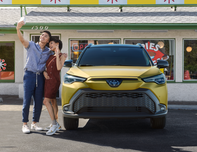 couple in front of a yellow Toyota